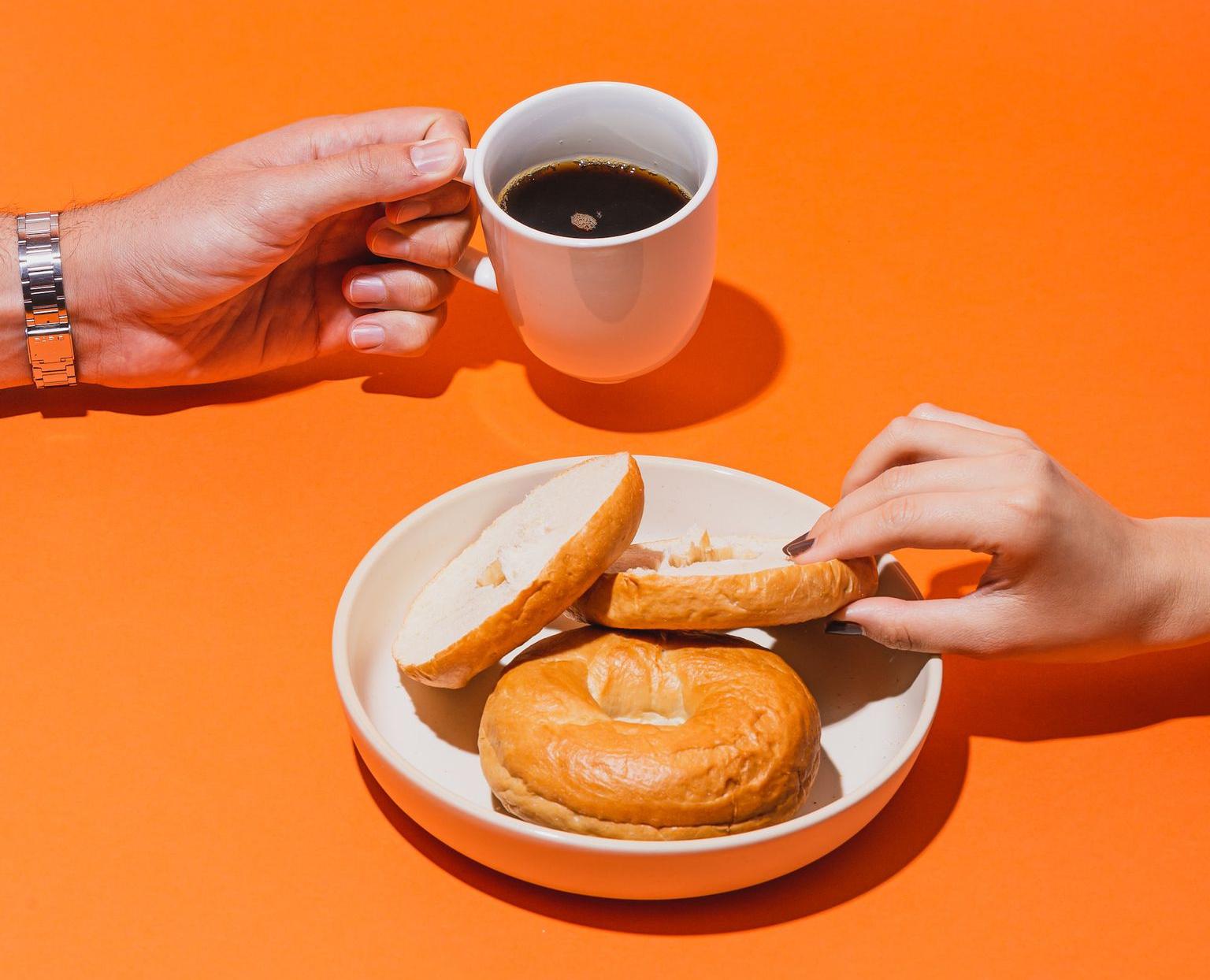 person holding white ceramic mug with brown liquid